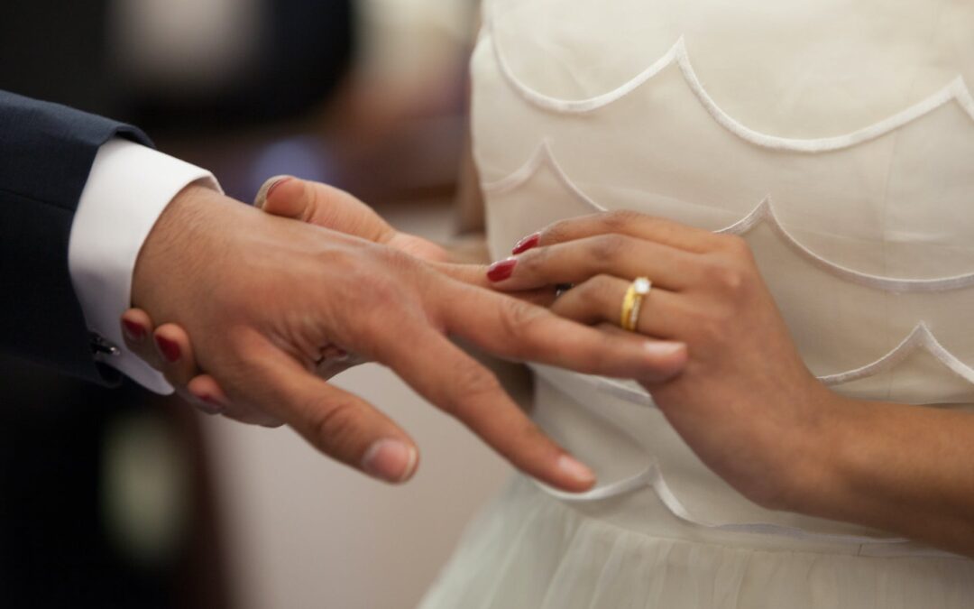 bride putting a ring on grooms hand