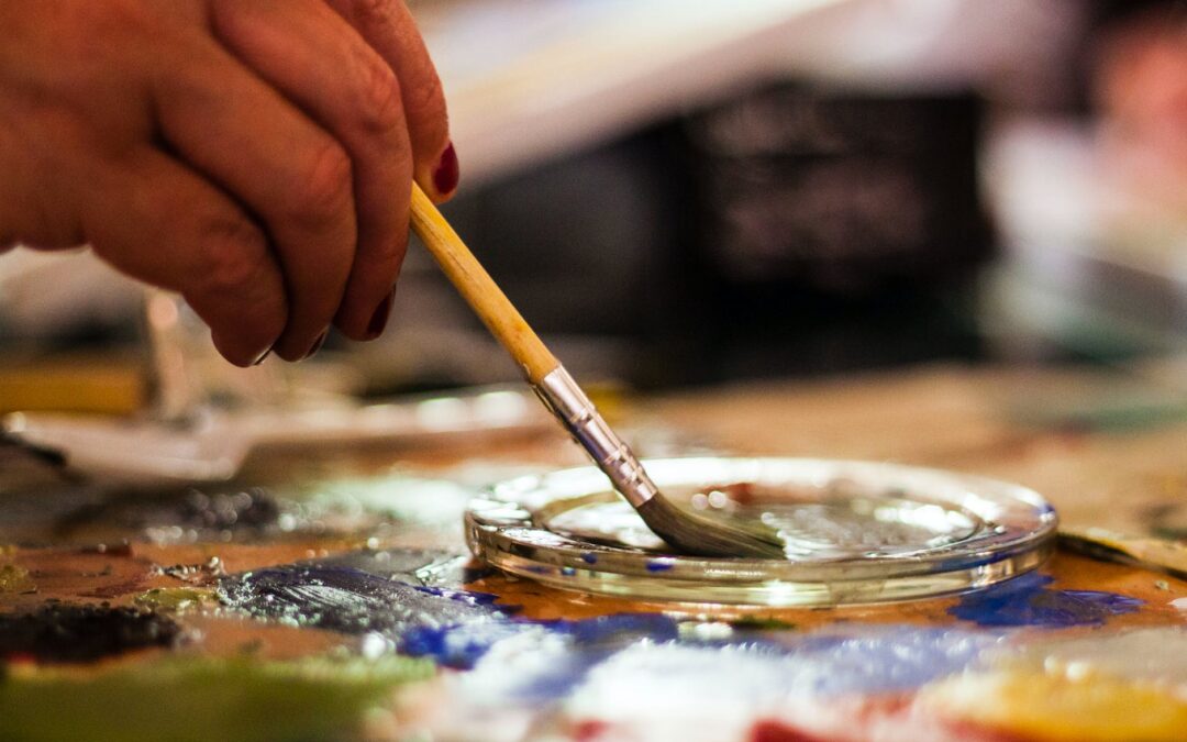 person holding brown and gray paint brush