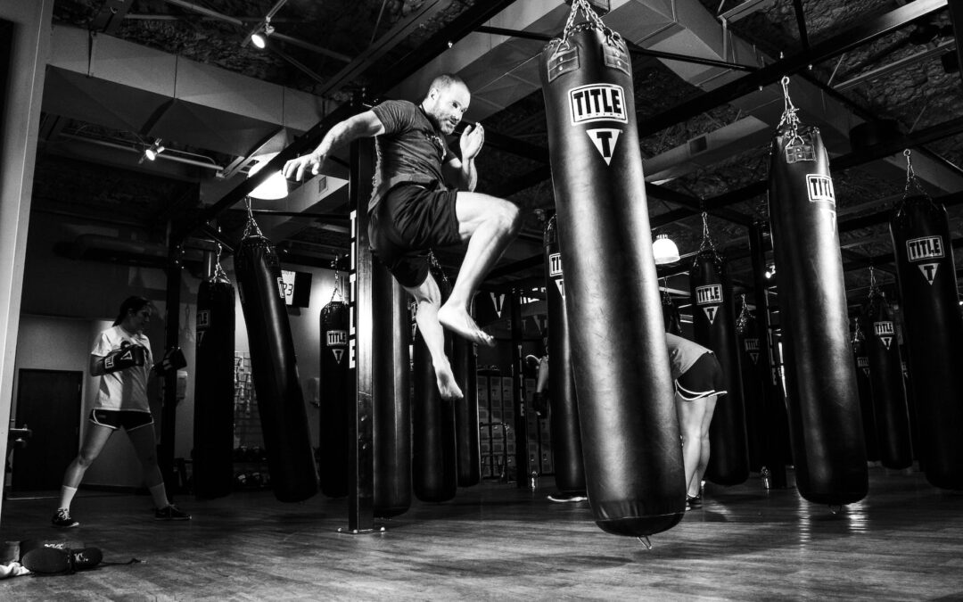 man kicking heavy bag