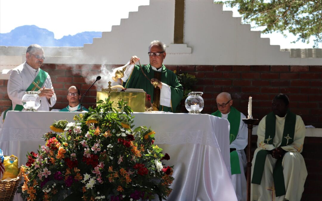 senior priest waving incense during church service near multiracial coworkers