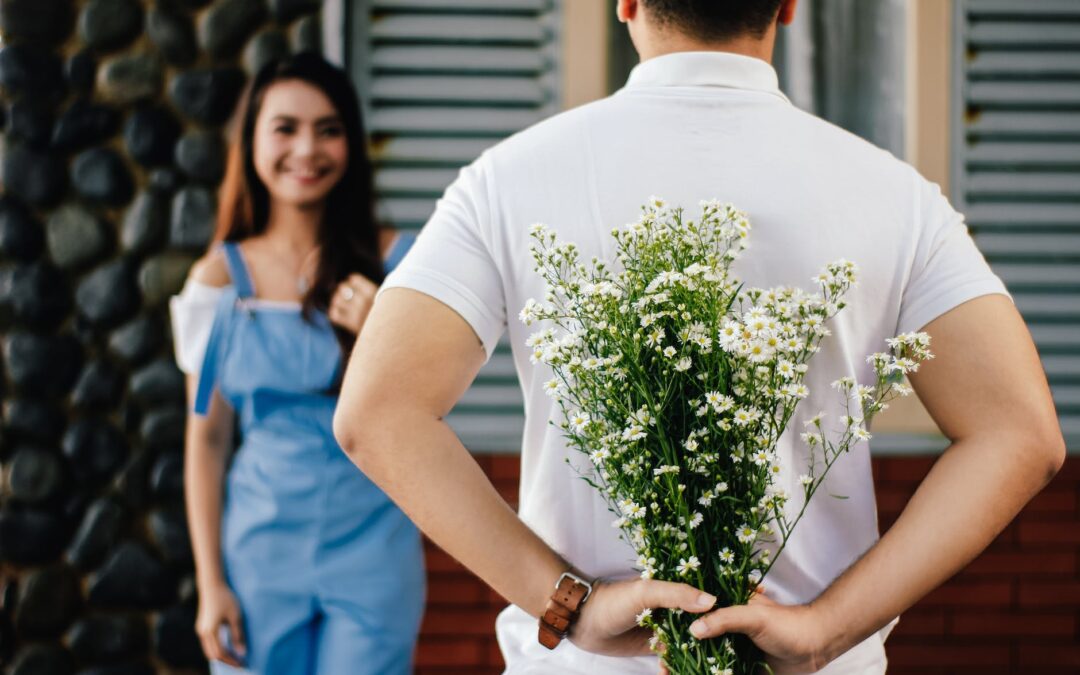 man holding baby s breath flower in front of woman standing near marble wall