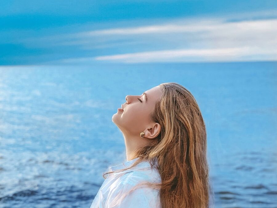 woman in white shirt standing near sea during daytime